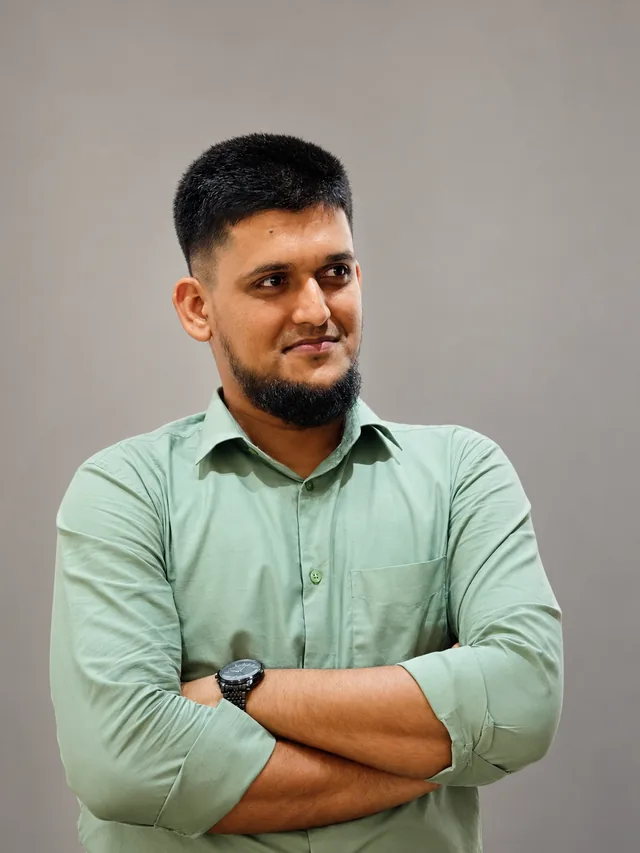 Kausar Rony, arms folded, in a light green shirt, looking to the side